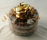 Three Tier Rounds | Chocolates - Round containers containing double dipped chocolate covered peanuts, chocolate covered caramel corn, and large chocolate covered raisins that are all tied together with a large bow.